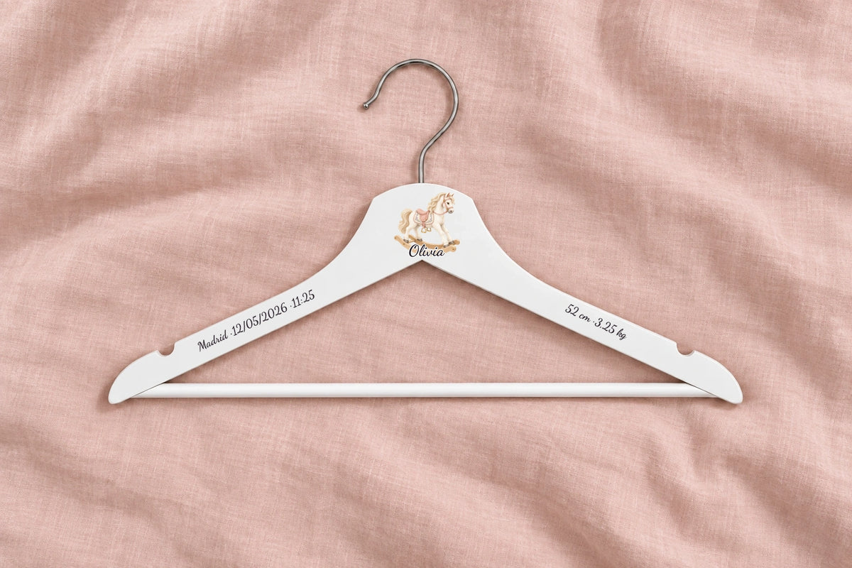Percha bebé blanca con caballito, nombre Olivia y fondo rosa