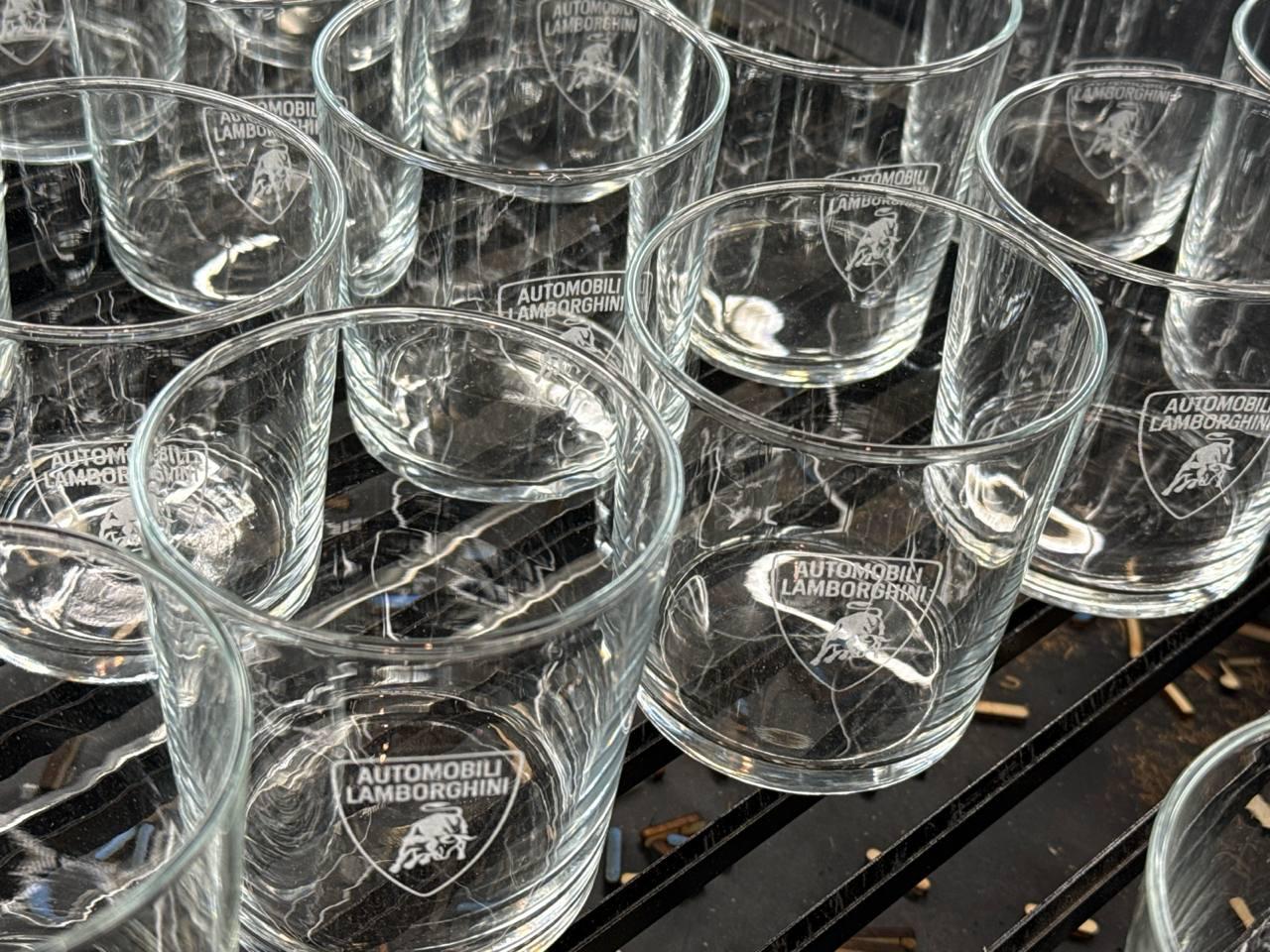 Varios vasos de cristal con el logotipo de Automobili Lamborghini grabado mediante láser de alta precisión.