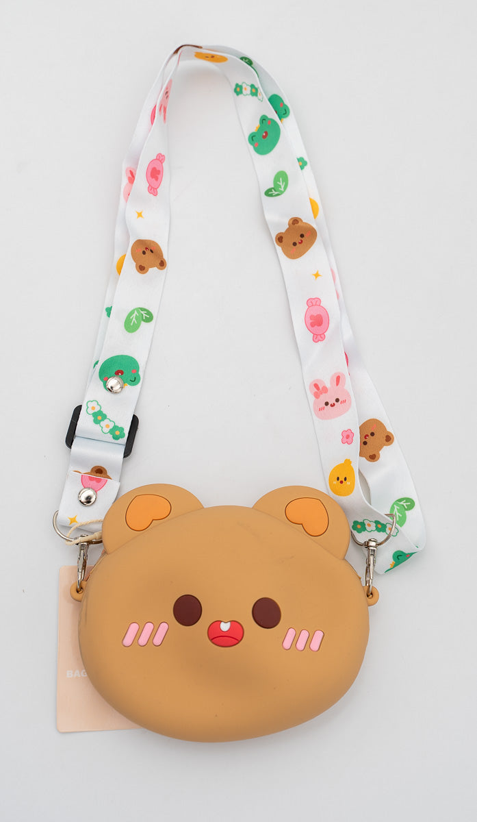 Bolso infantil de silicona marrón con cara de oso y mejillas rosadas.