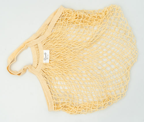 Bolsa de malla color crema con tejido calado y asas superiores integradas.