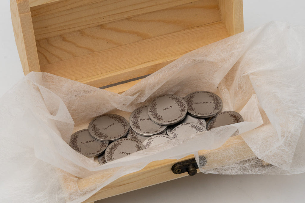 Coffre en bois ouvert avec pièces de mariage enveloppées dans du papier protecteur blanc