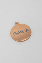 Cara posterior de medalla rosada para perro con el nombre BIMBA grabado a láser