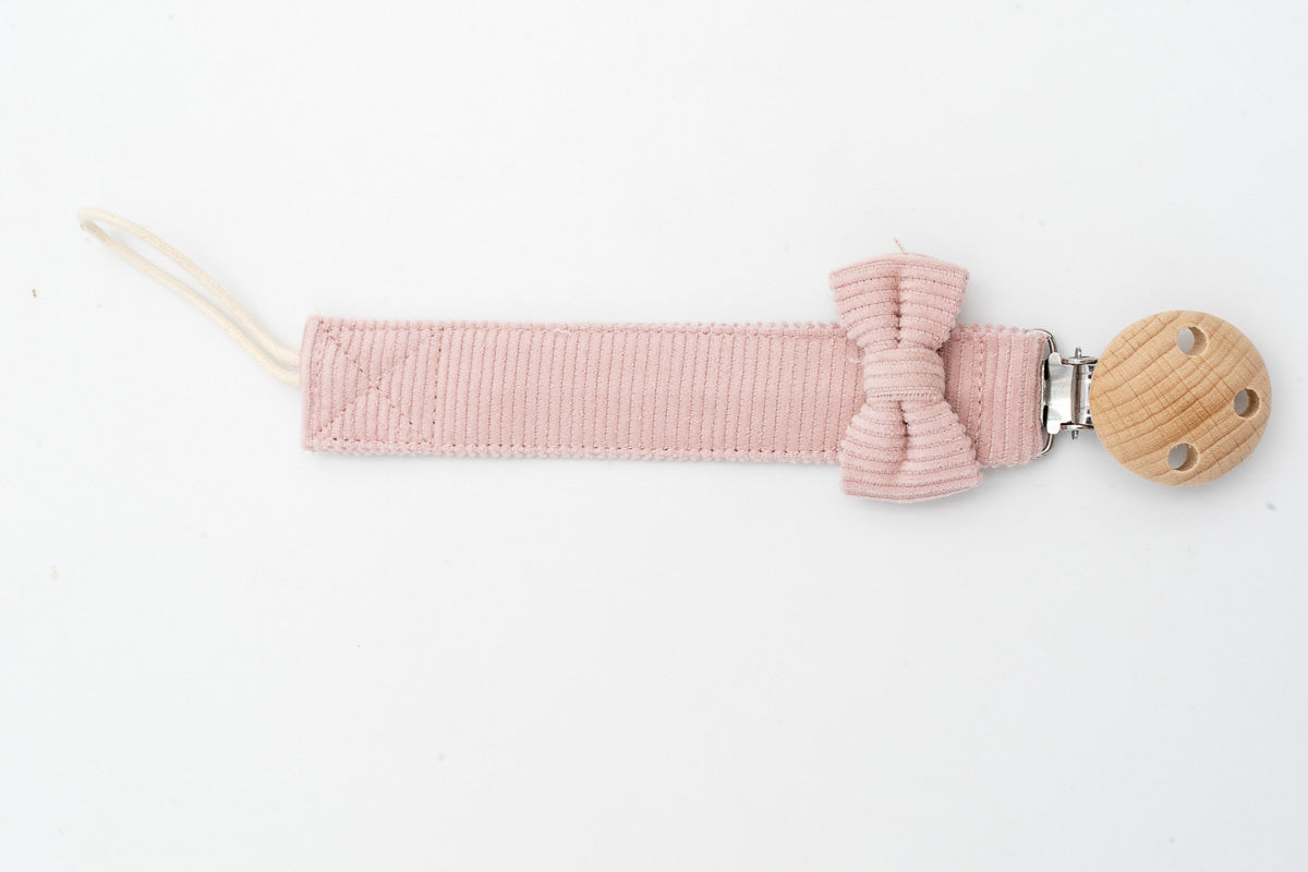 Attache-tétine rose avec nœud près du clip rond en bois