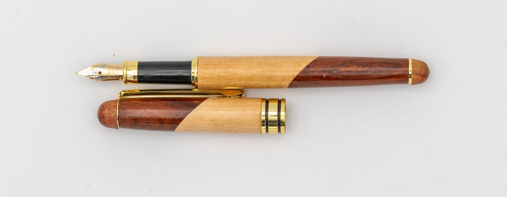 Vue latérale d'un stylo plume en bois bicolore avec plume et capuchon à clip doré.