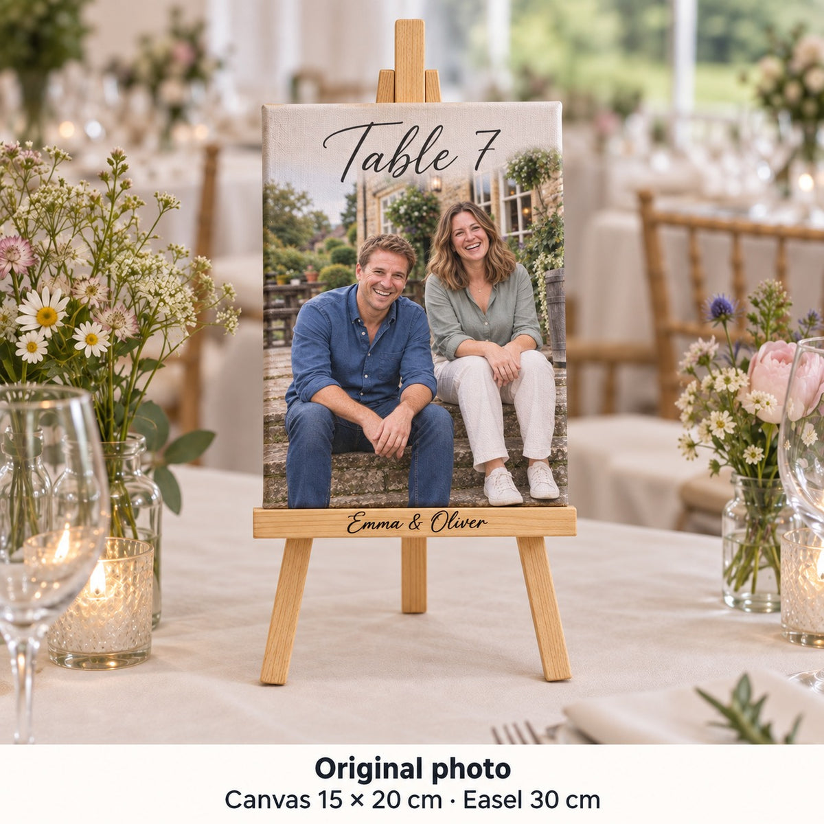 Toile de 15 × 20 cm avec photo d’Emma et Oliver avant le mariage et « Table 7 », sur chevalet au centre d’une table de réception.