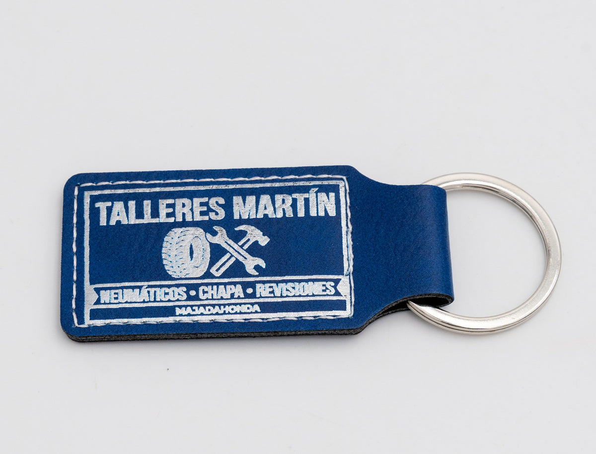 Porte-clé rectangulaire bleu avec dessin de garage automobile en teinte claire.