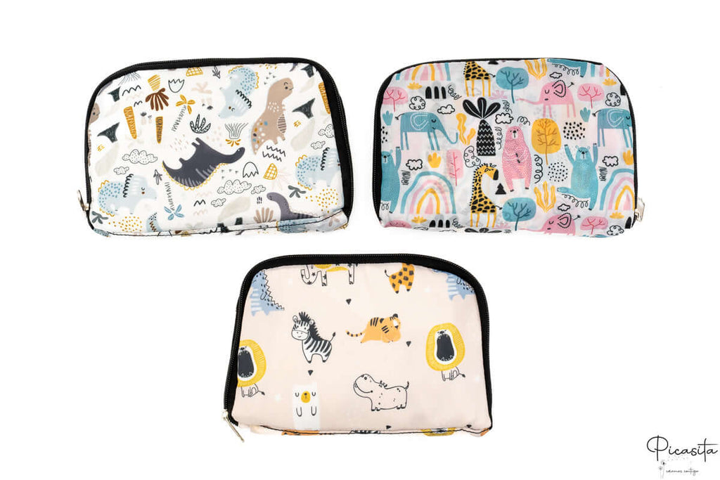 Tres neceseres plegados que muestran los tres estampados disponibles de la colección infantil.