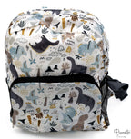 Mochila infantil blanca con estampado de dinosaurios en tonos azules, grises y marrones.