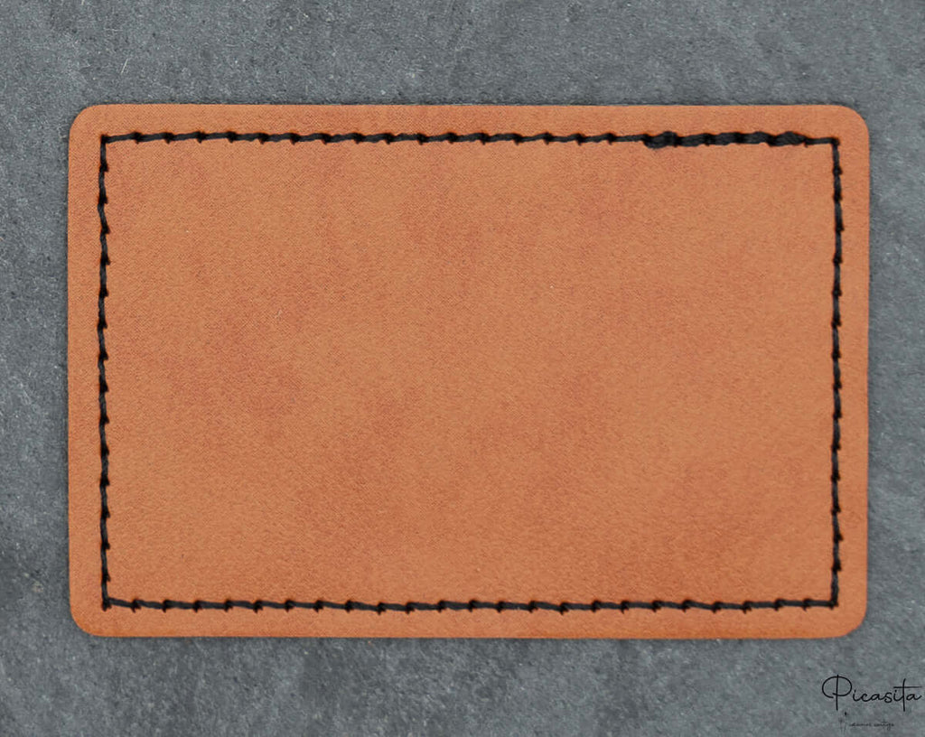 Parche rectangular de polipiel con esquinas redondeadas y costura decorativa negra perimetral.