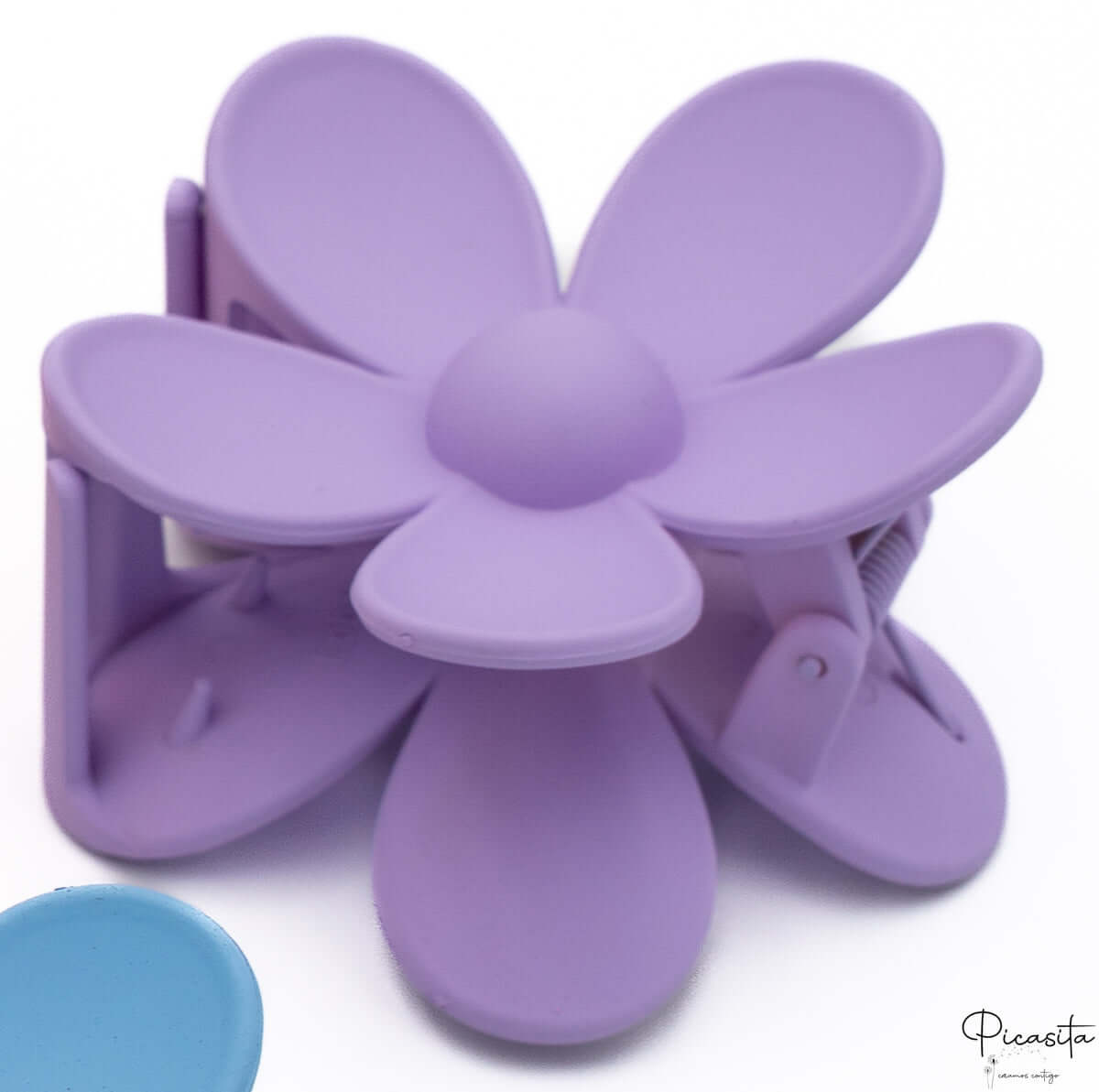 Detalle de pinza para el pelo con forma de flor en color morado lila con acabado mate.