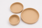 Tres platos de silicona beige de 17, 15 y 10 cm dispuestos sobre un fondo claro