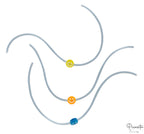 Tres pulseras elásticas grises con cuentas de sonrisas en amarillo, naranja y azul.