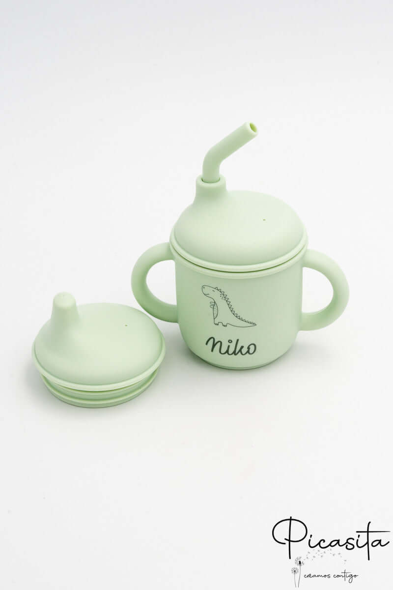 Vaso infantil verde clarito de silicona con pajita y tapa de boquilla adicional.