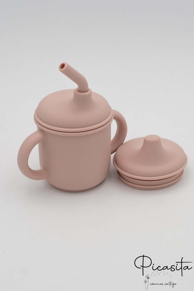 Vaso irrompible rosa clarito con accesorios de silicona para alimentación infantil.