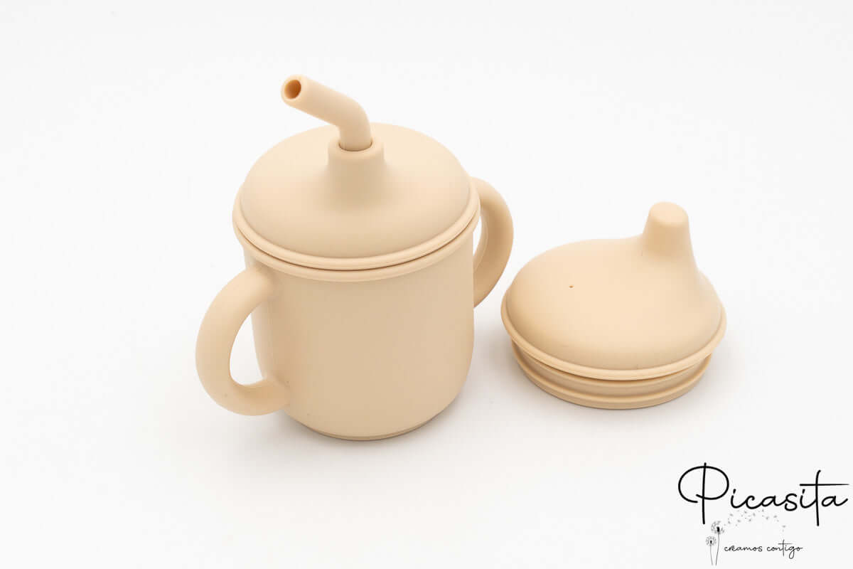 Vaso infantil beige con accesorios desmontables de silicona de grado alimentario.